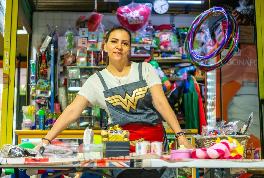 Woman proudly standing at her colorful market stall in Ciudad de México.